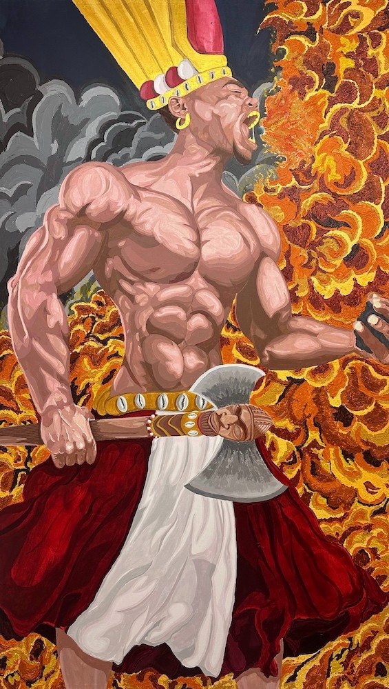 A muscular, bare-chested warrior in a red skirt and white sash shouts fiercely amid swirling flames. He wears a tall, yellow feathered headdress and gold earrings, gripping a double-headed axe decorated with gold and eyes. Smoke billows in the background.