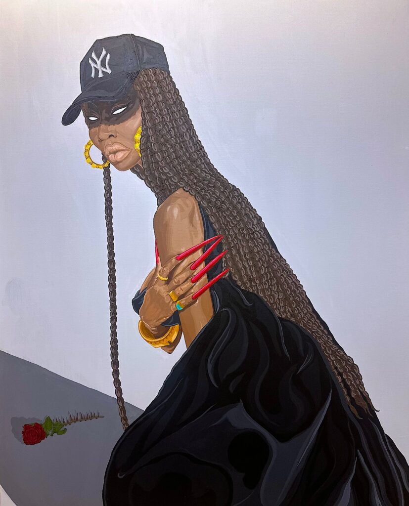 A woman with long, braided hair wears a black NY cap, gold hoop earrings, and claw-like red nails. She is dressed in a flowing black outfit, with gold jewelry, and holds her shoulder. A single red rose lies on the ground near her. The background is plain.